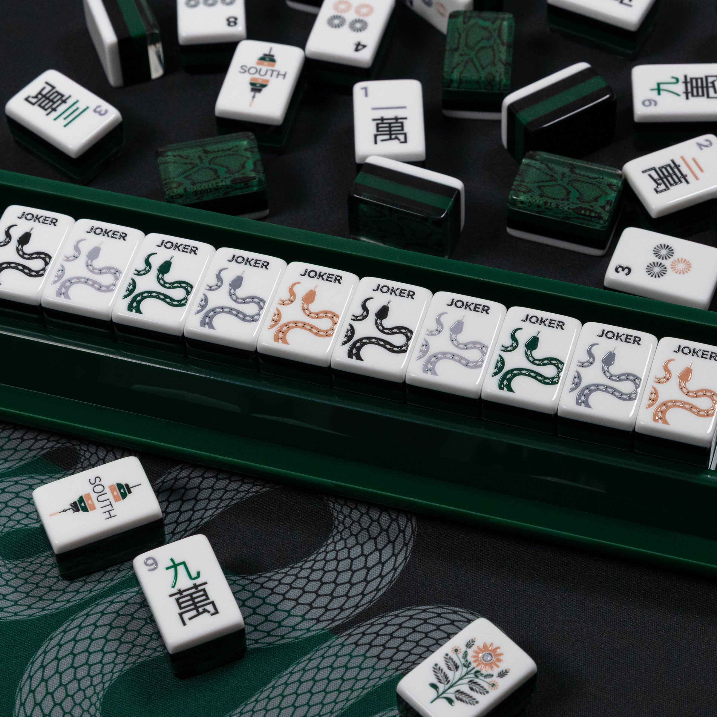 Mahjong tiles with various designs on a dark surface